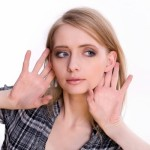 woman holding hands to ears to indicate listening